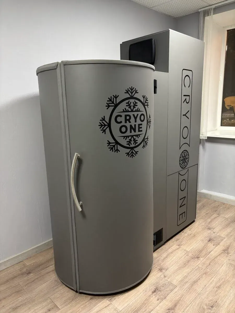 Криокапсула CryoOne Business: серая закрытая кабина и блок агрегата с дисплеем в кабинете