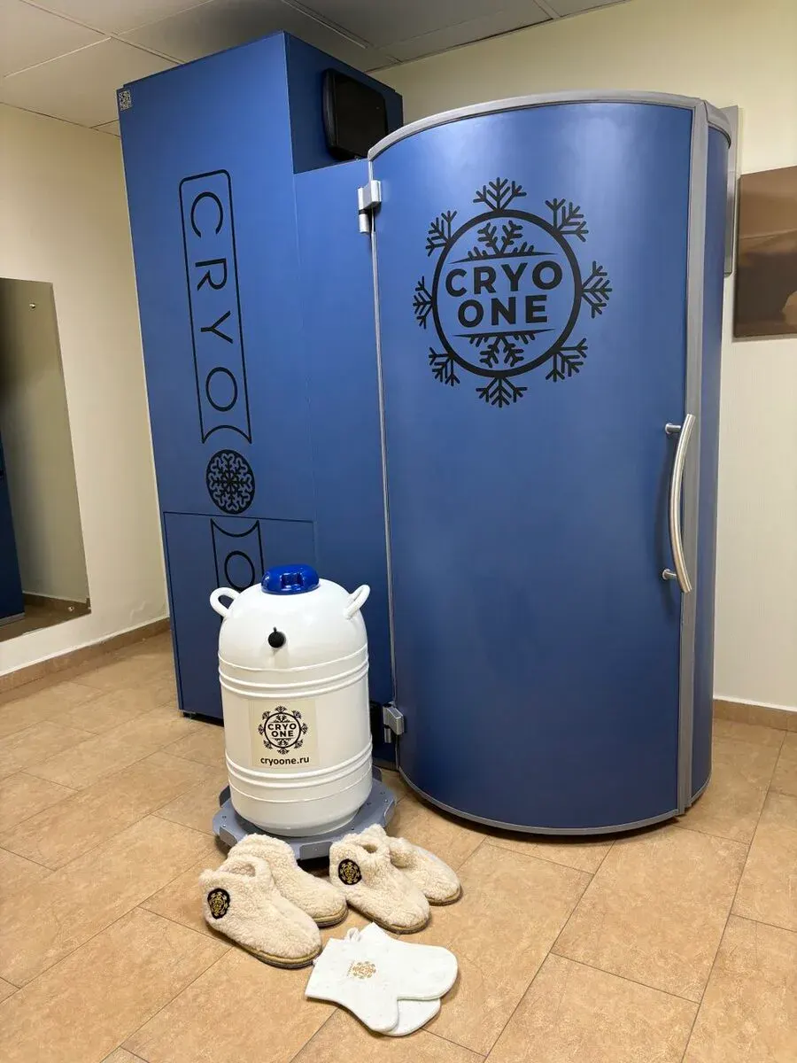 Криокапсула CryoOne Comfort: синяя кабина, блок агрегата и белый сосуд Дьюара рядом