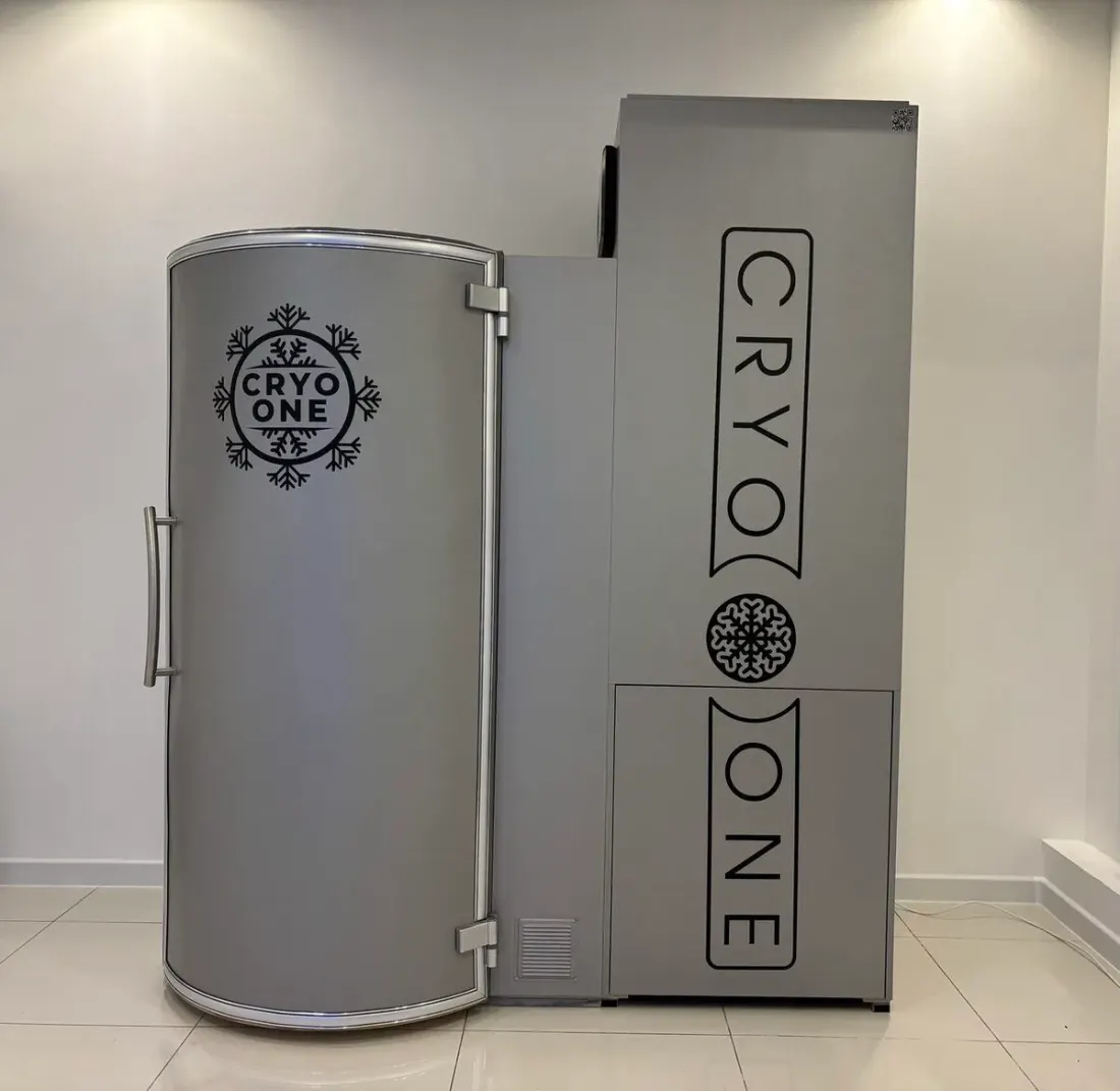Криокапсула CryoOne Standard: серая кабина с приоткрытой дверью и блок агрегата рядом